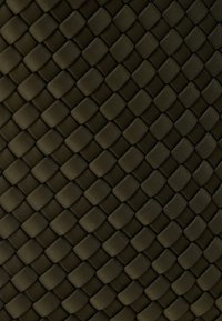 Υφασμα υφαντό σε σκούρο πράσινο με υφή μοτίβου. Ορθογώνια σχήματα διαπλέκονται, δημιουργώντας μια ανθεκτική και απτική επιφάνεια.