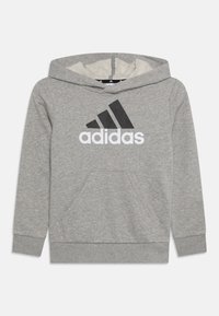 Felpa grigia con cappuccio, realizzata in tessuto morbido. Presenta un grande logo Adidas nero sul davanti e una tasca a marsupio centrale.