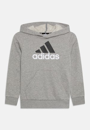 Sudadera con capucha gris, hecha de una tela suave. Presenta un gran logo negro de Adidas en el frente y un bolsillo canguro central.