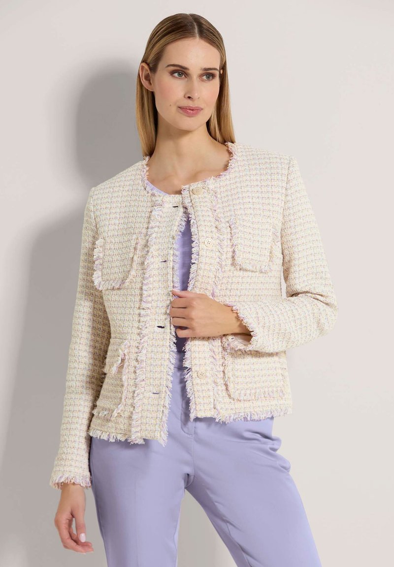 Geweven tweed jasje in pastelkleuren met rafelige randen, ronde halslijn en twee voortassen, gecombineerd met een lichtpaars top.