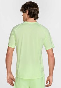 Ljusgrön tränings T-shirt med korta ärmar. Slät textur, rundad halsringning och diskreta accentlinjer på ryggen.
