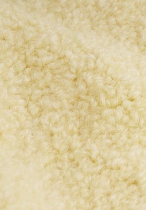 Miękka, teksturowana tkanina w jasnożółtym kolorze, charakteryzująca się puszystą, pętelkową powierzchnią z misternymi włóknami tworzącymi ciepły, przytulny wygląd.
