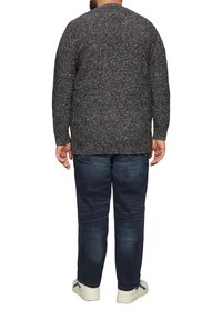 Donkergrijze gebreide trui met een textuurpatroon, ronde halslijn en lange mouwen, gecombineerd met donkerblauwe spijkerbroek en witte sneakers.