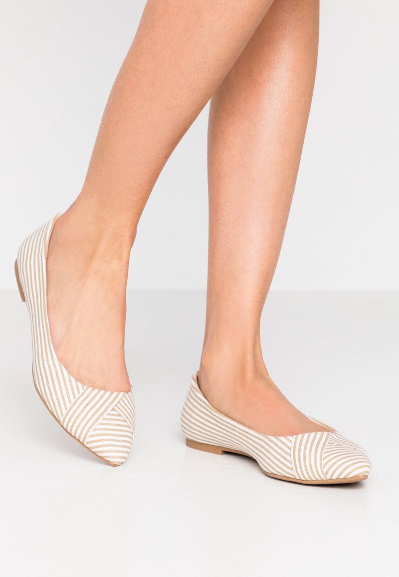Randiga ballerinas i beige och vit tyg, med rund tå, låg klack och skurna sidor. Texturerad ovandel med diagonala ränder.