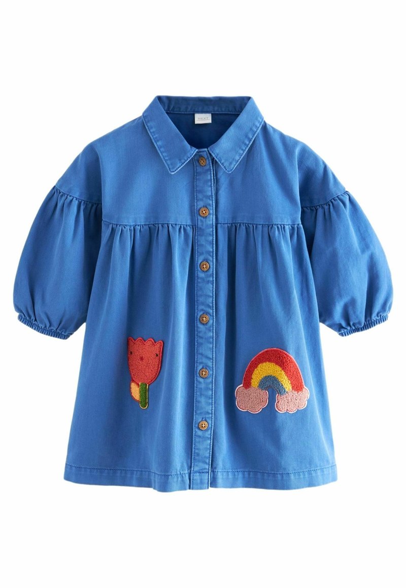 Chemise bleue en coton avec des manches courtes ballons, à bouton sur le devant, ornée de motifs brodés de fleurs et d'arcs-en-ciel sur le bas.
