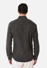 Camicia in denim grigio scuro con colletto button-down, maniche lunghe e orlo curvato, realizzata in tessuto leggermente testurizzato e dotata di polsini con bottone.