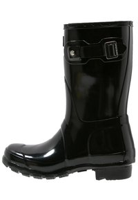 Botte de cheville noire en caoutchouc imperméable avec une finition brillante, sangle réglable et détails en boucle, semelle texturée pour une meilleure adhérence.