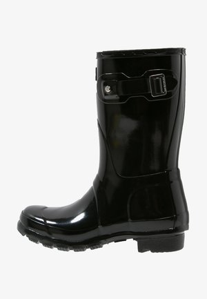 Bota de tornozelo de borracha preta e à prova d'água com acabamento brilhante, tira ajustável e detalhe de fivela, sola texturizada para aderência.