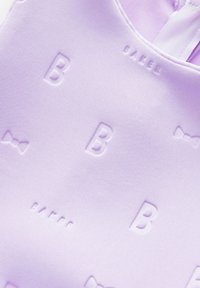 Lila tkanina z utisnjenimi črkami "B" in imenom "BAKER," z gladko teksturo in subtilnimi vzorci pentelj po celotni površini.