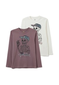 Due magliette a maniche lunghe: una color malva con uno scheletro grafico e un cappello, l'altra bianca con un design simile ma con una stampa diversa.