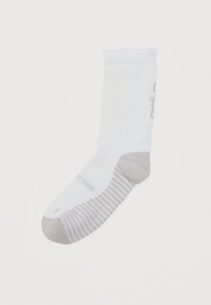 Single white calf-length sock with gray toe, heel patches, and horizontal stripes on the foot sole against a plain background.