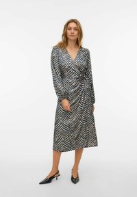 Aptīšanas kleita ar rakstainu audumu, ar V-veida izgriezumu, gariem piedurknēm un jostu viduklī. Krāsas: melna, bēša un metāliskas nianses.