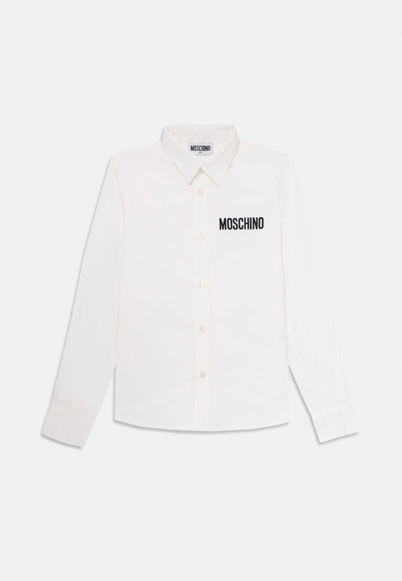 Hvit langermet skjorte med krage og svart "MOSCHINO"-tekst på venstre bryst, lagt flatt på en hvit bakgrunn.