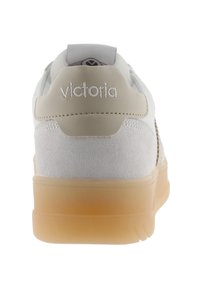 Vit sneaker med beige accenter, toalettläder och släta lädertexturer, gummisula, vadderad krage och "victoria"-logotyp på hälen.