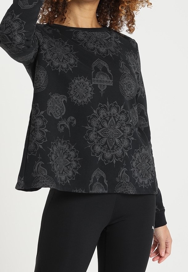 Top nero a maniche lunghe con scollatura rotonda, caratterizzato da un motivo paisley testurizzato. Tessuto morbido con una vestibilità comoda. Abbinato a leggings neri.