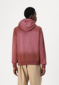 Hooded sweatshirt in a gradient rose color, made of soft fabric, featuring a relaxed fit and ribbed cuffs. Minimalist design with a smooth texture.