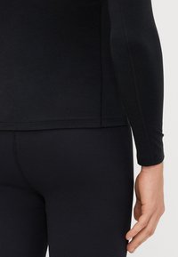 Musthave tume pikka varrukaga särk sileda materjali, hästi istuv disain. Mustad ribidega legaalsed kõrge vöökoht ja õmblustega detailid.