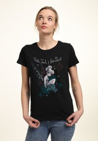 Svart bomulls t-shirt med en färgglad grafik av en fe omgiven av blommor och text. Rund halsringning och korta ärmar.