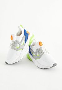Sport sneakers med en hvid mesh-overdel, grå accenter, blå og orange detaljer og en lys grøn sål. Snørret design med polstret krave.