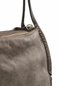 Borsa a tracolla in pelle grigia con superficie texturizzata, dotata di una cerniera dorata e dettagli con borchie lungo il lato. Cinghia attaccata.