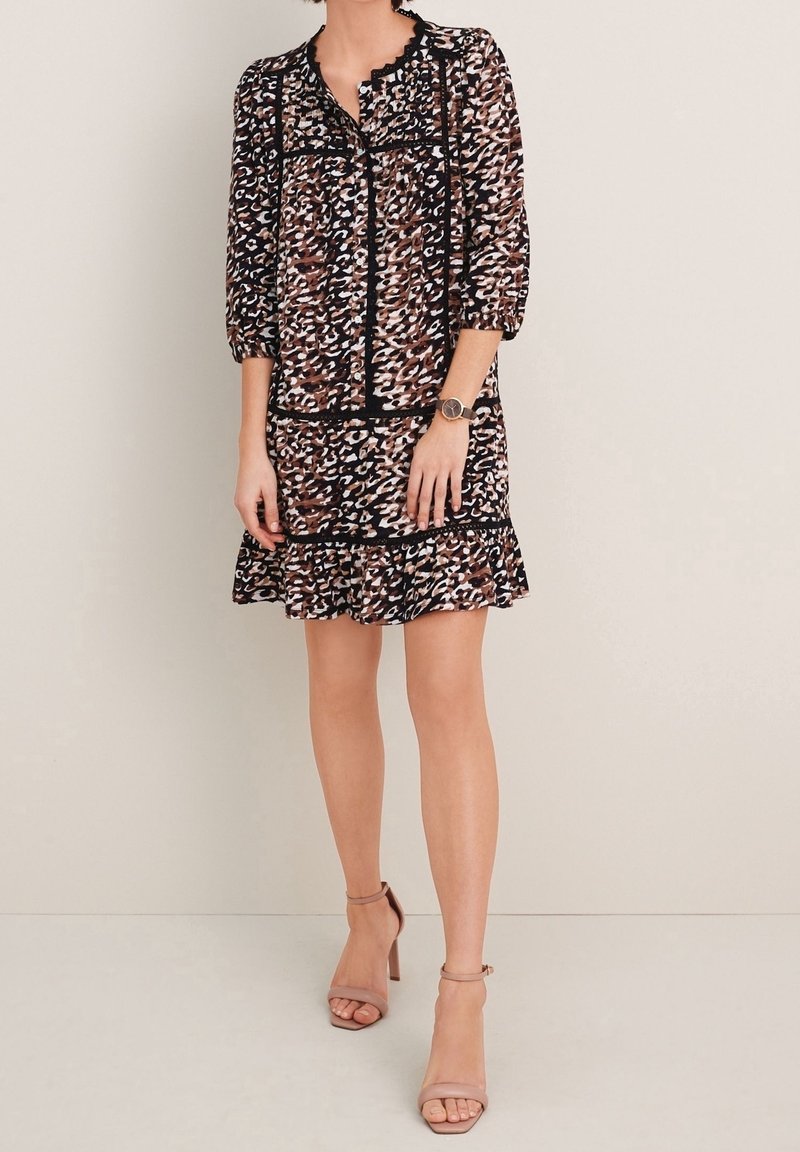 Robe à imprimé floral avec des manches mi-longues, un col en dentelle, un contour noir et un ourlet volanté. Le matériau semble léger et fluide.