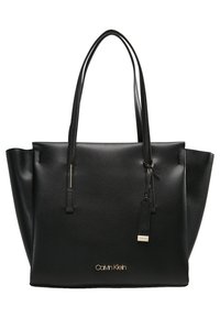 Black leather tote bag with flat handles, wide open top, subtle gold hardware, and embossed "Calvin Klein" logo on front. Smooth texture.