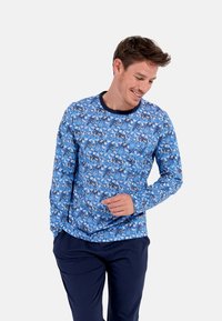 Langärmliges Hemd in Blau mit floralem Muster. Verfügt über einen runden Ausschnitt mit marinefarbener Borte und einer lockeren Passform. Glattes, leichtes Material.