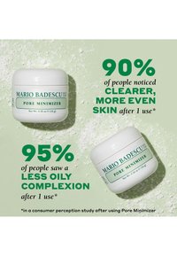 Weiße Kunststoffbehälter mit der Aufschrift "Mario Badescu Pore Minimizer" auf einem hellgrünen Hintergrund, umgeben von verstreutem weißem Pulver.