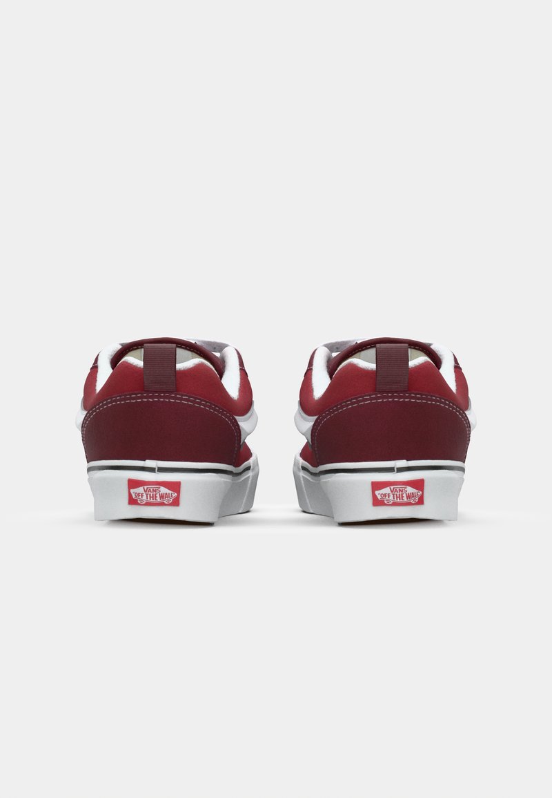 Rode canvas sneakers met witte accenten, voorzien van een vlakke zool, een gevoerde kraag en een trekband aan de achterkant. Logo weergegeven aan de achterkant.