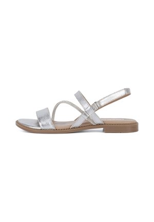 Strieborné kovové sandále s plochou podrážkou, ktoré majú dva široké popruhy cez prsty a krížový dizajn na priehlavku.
