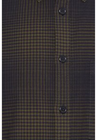 Checkered button-up shirt in dark navy and olive green. Features a classic collar, two black buttons, and a pocket on the left side.