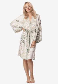 Szlafrok z kwiatowym wzorem o jasnym kremowym tle, z rękawami kimono i paskiem w talii. Posiada satynowe wykończenie i miękką teksturę.