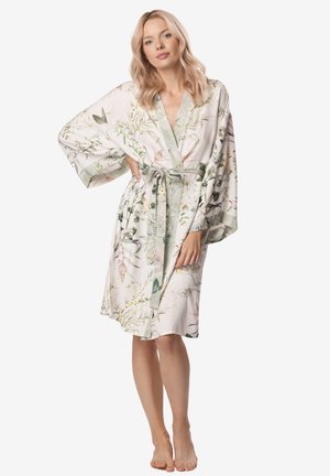 Szlafrok z kwiatowym wzorem o jasnym kremowym tle, z rękawami kimono i paskiem w talii. Posiada satynowe wykończenie i miękką teksturę.