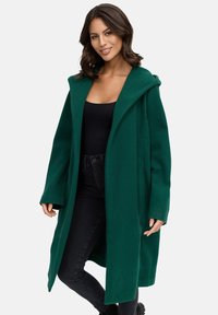 Green wool coat with a wide hood, open front, and long sleeves. Features a relaxed fit; textured fabric; embroidered logo on the sleeve.