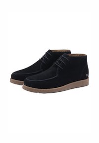 Bottines en suède noir avec un bout rond, un laçage, des coutures contrastantes et une semelle en caoutchouc brun clair.