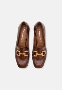 Brown glossy leather loafers with a square toe, featuring a gold-tone hardware detail across the front and a smooth inner lining. Size 37.