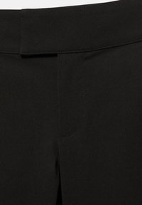 Ceinture noire et braguette avant de pantalon ajusté avec des coutures nettes et sans boutons ni fermetures éclair visibles.