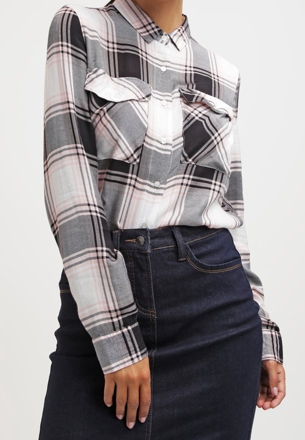 Camicia a maniche lunghe con bottoni in una fantasia a scacchi grigia, nera e rosa, con due tasche sul petto e colletto, abbinata a una gonna di denim scuro.