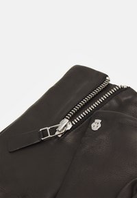 Schwarze Lederhandschuhe mit einem silbernen Reißverschluss und Hardware-Akzenten. Das Material hat eine glatte Textur mit einem dezenten Glanz.