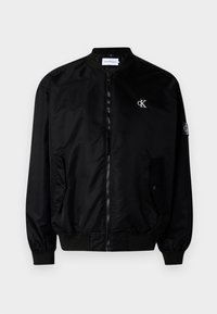 Giubbotto bomber nero realizzato in nylon lucido, dotato di zip frontale, due tasche laterali, polsini e orlo a coste, con un piccolo logo sul petto.