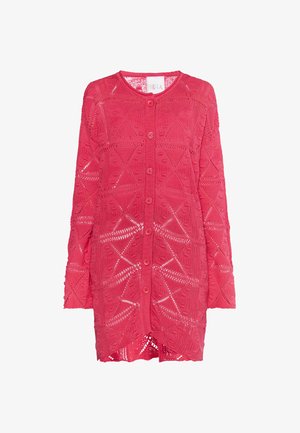 Rozā adīta cardigan ar ģeometrisku atvērtu tekstūru, garām piedurknēm un priekšējo pogu aizdari. Mīksta tekstūra un viegls dizains.