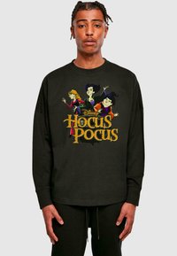 Čierne tričko s dlhým rukávom, na ktorom je farebná karikatúra troch čarodejníc a žltý nápis "Disney Hocus Pocus".