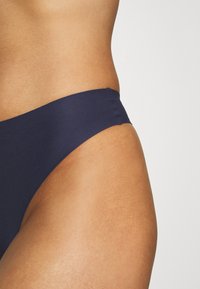 Navy blauwe bikini onderkant gemaakt van soepel, rekbaar materiaal. Heeft een minimalistisch ontwerp met een lage taille en naadloze randen.