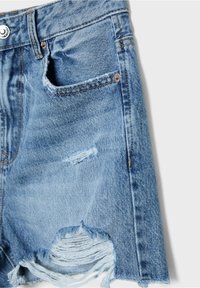 Short en denim bleu clair avec des détails usés, incluant des trous effilochés au-dessus et près de l'ourlet, et une petite poche avant visible.