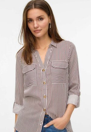 Camicia button-up con righe verticali bordeaux e bianche, due tasche sul petto, maniche arrotolate e bottoni marroni. Tessuto morbido e lavorato.