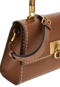 Bruine leren handtas met een gestructureerde vorm, voorzien van gouden hardware, contrasterende stiksels en een korte handgreep.