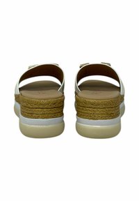 Sandali bianchi con una fascia larga, fibbia laterale e una piattaforma in corda intrecciata beige. La suola è piatta e con una finitura liscia.