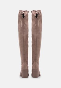 Kozačky do výšky kolen, z taupe suede, s kulatou špičkou, blokovým podpatkem a nastavovacím vázáním na vrchu. Hladký povrch a vertikální švy.