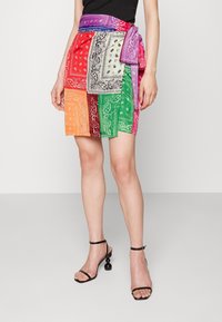 Kleurrijke mini-jurk met bandana-print, featuring patchwork-design in levendige tinten van rood, groen, oranje en paars, met een gestrikte taille.