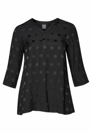 Schwarze Bluse mit Dreiviertelärmeln, die ein dezentes Pünktchenmuster und einen flachen V-Ausschnitt aufweist. Hergestellt aus einem glatten, leichten Stoff.